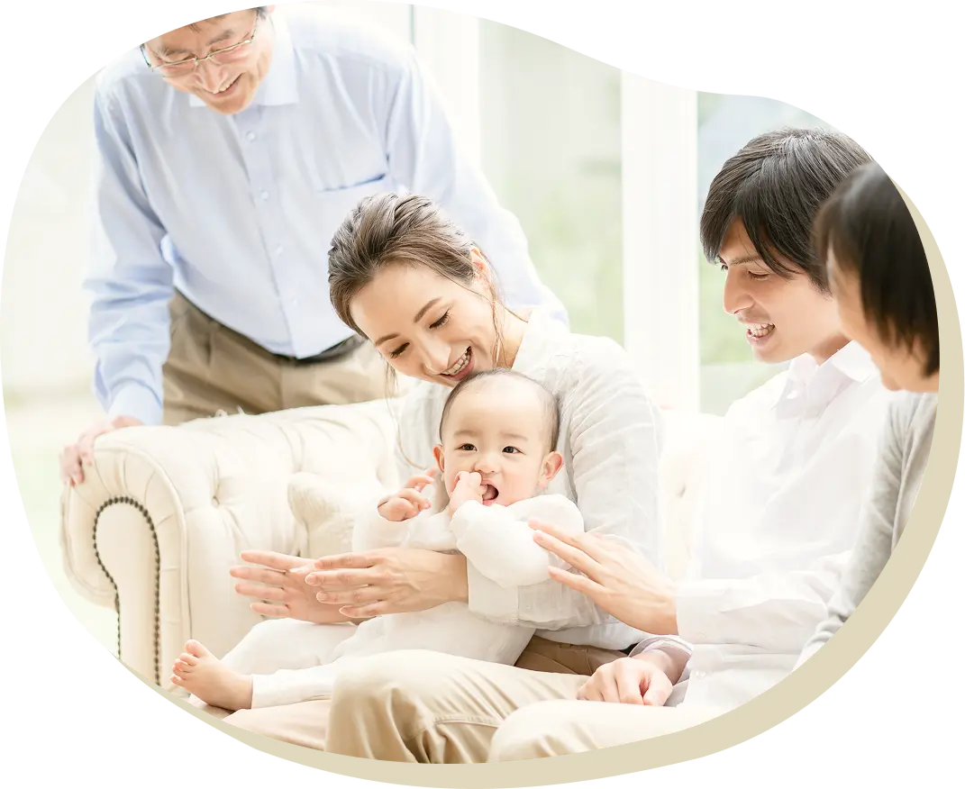 赤ちゃんを囲む笑顔の家族のイメージ